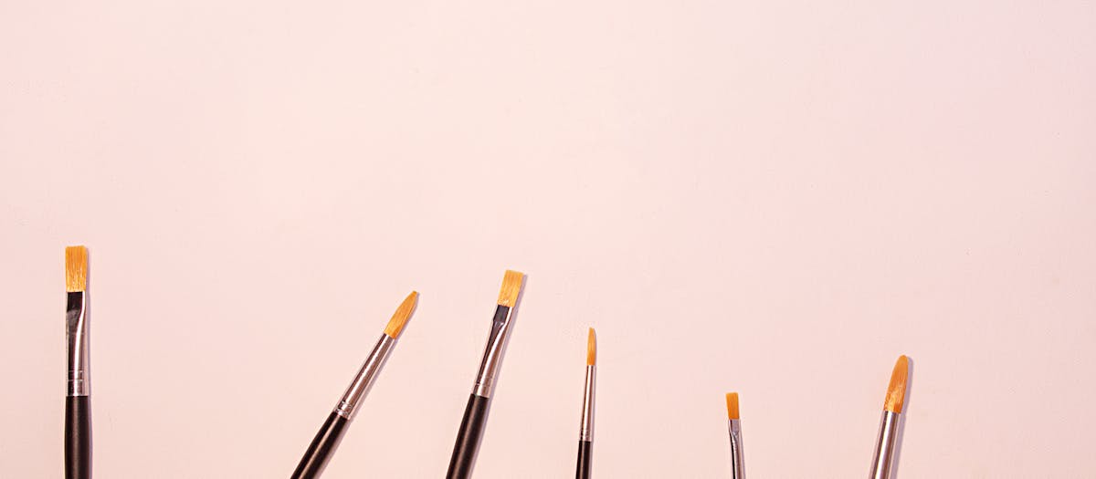 A variety of paintbrushes in different sizes against a clean white background, perfect for artistic themes.